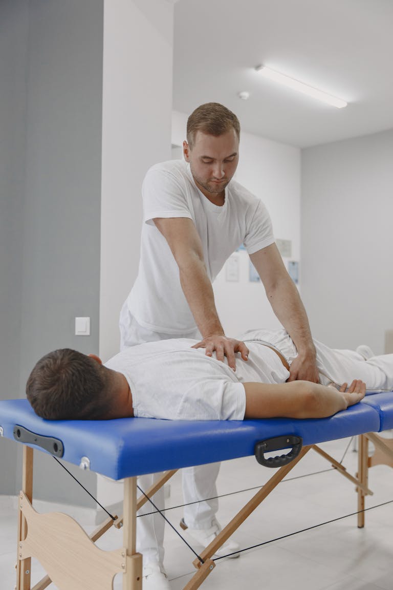 Chiropractor conducting a therapy session for back pain relief in a massage room.